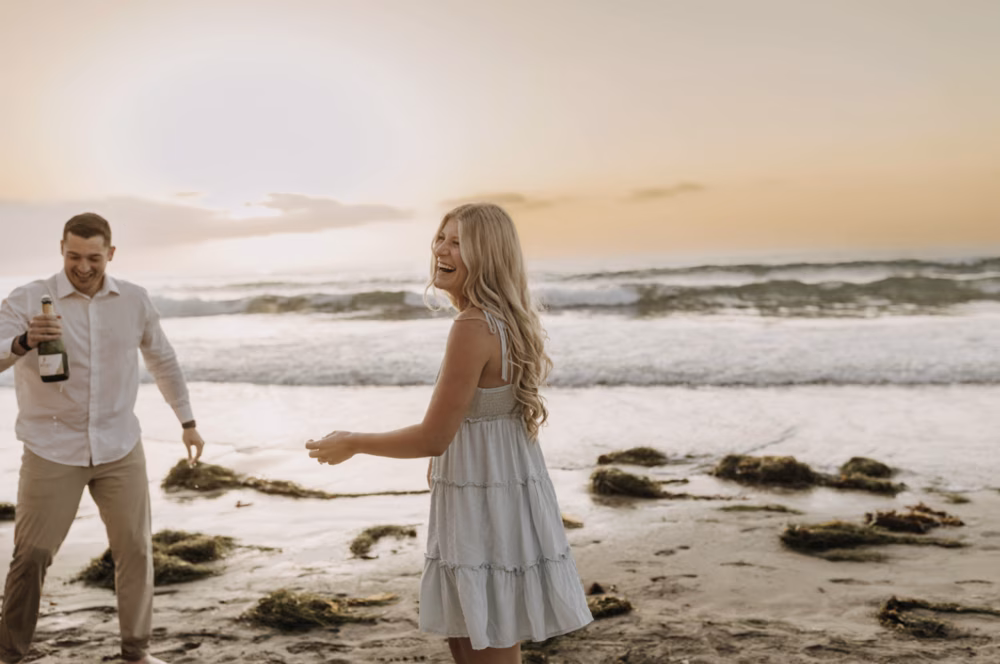 recently engaged couple celebrating on beach