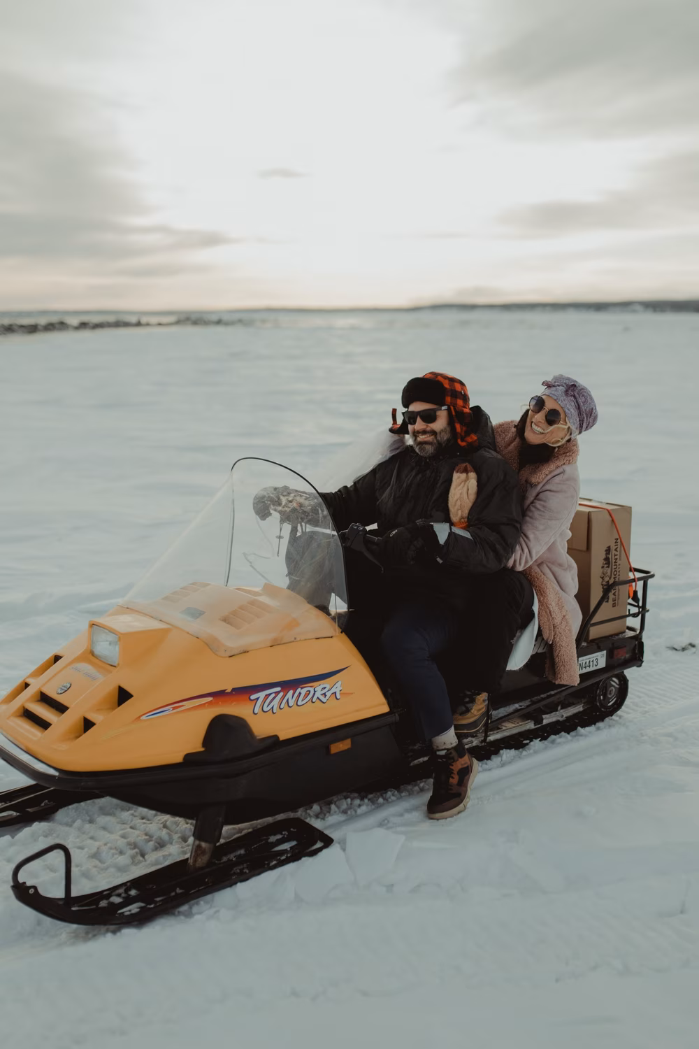 couple riding snowmobile on wedding day