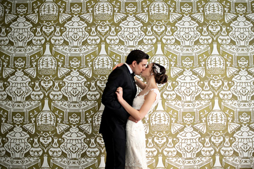 bride and groom kissing in from of gold and white wallpaper backdrop, photo by Kristen Weaver Photography bride and groom kissing in from of gold and white wallpaper backdrop, photo by Kristen Weaver Photography