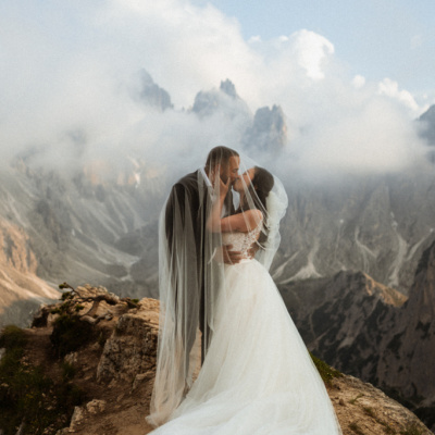 Kissing engagement photo above the clouds in Cadini di Misurina, Dolomites, Italy