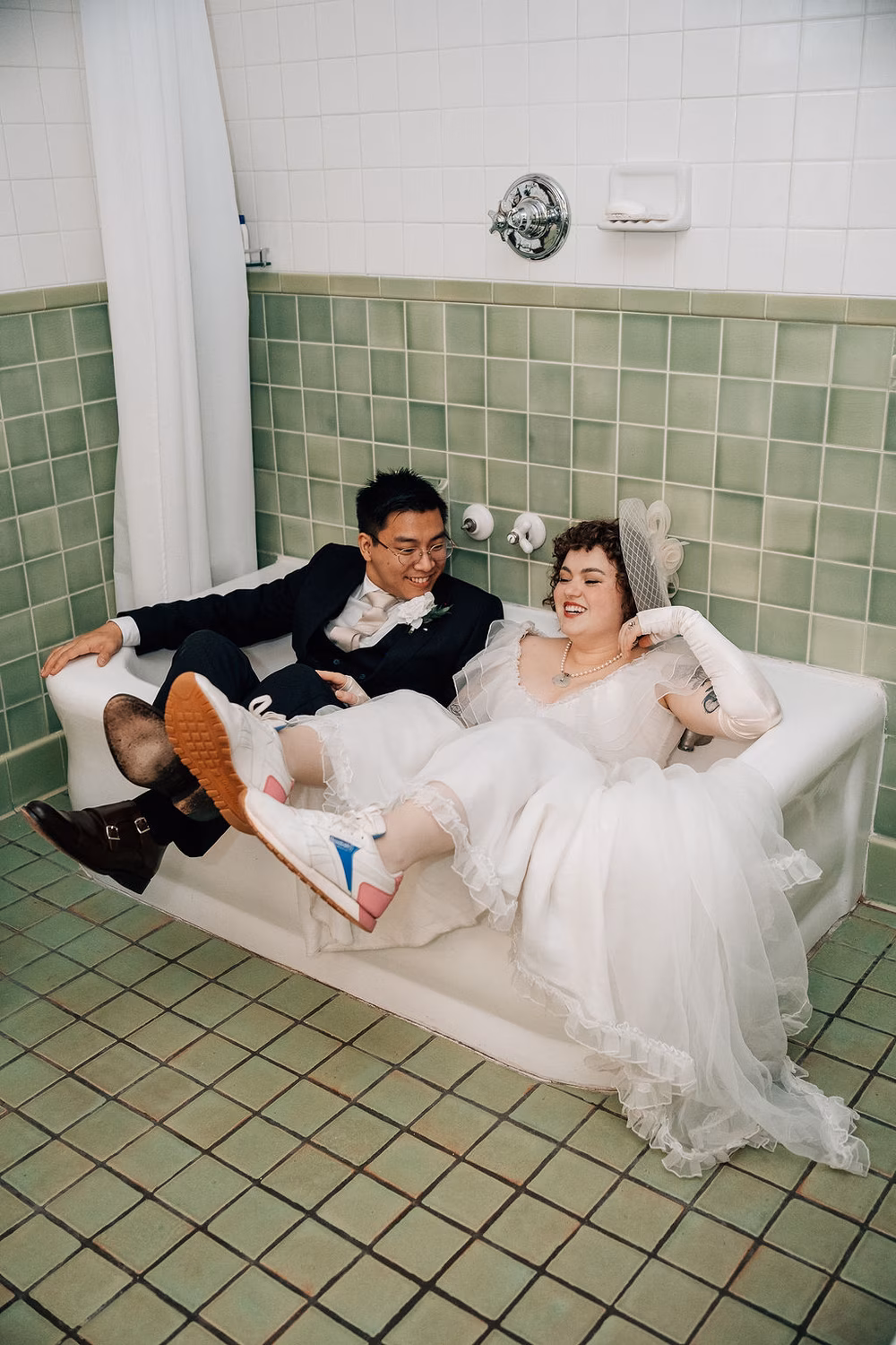 bride in vintage wedding dress sitting in bathtub