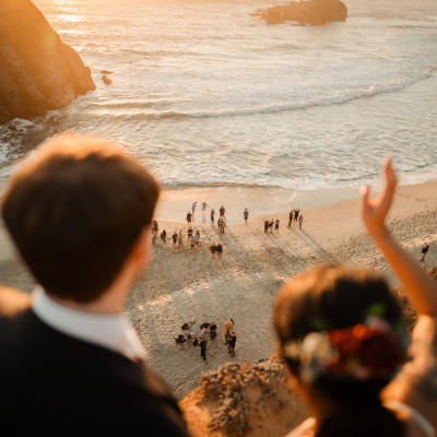 Newlyweds waving to a crowd at the beach in Big Sur