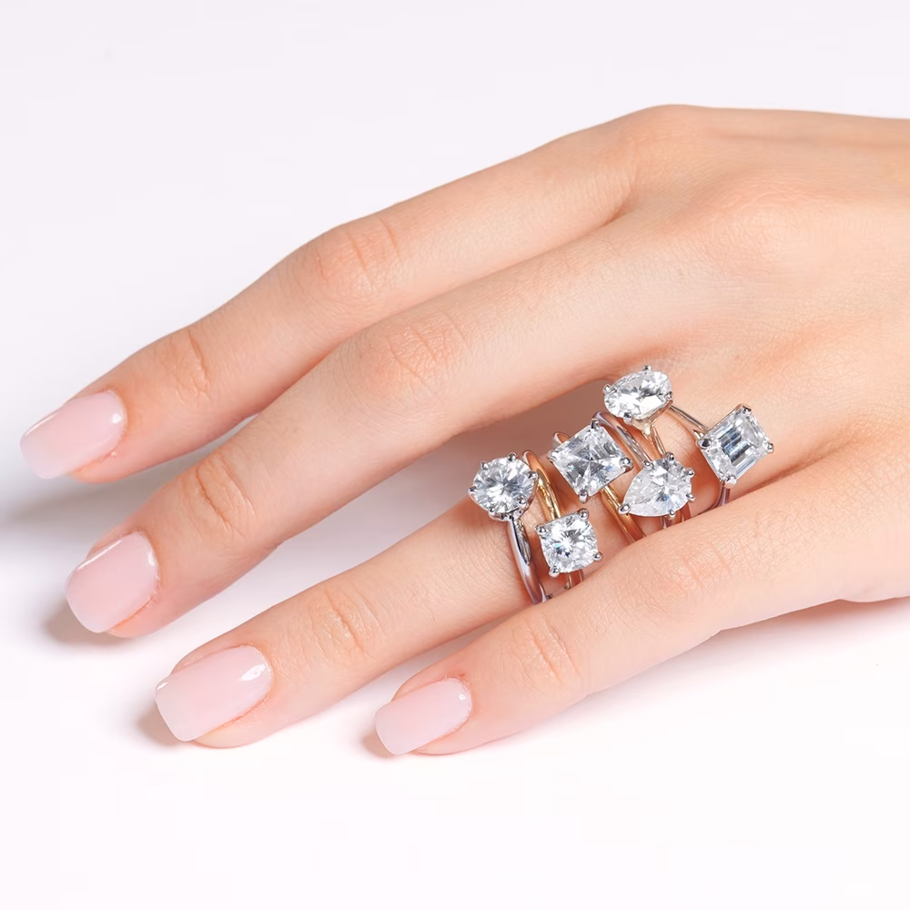 Hand wearing six different types of engagement rings
